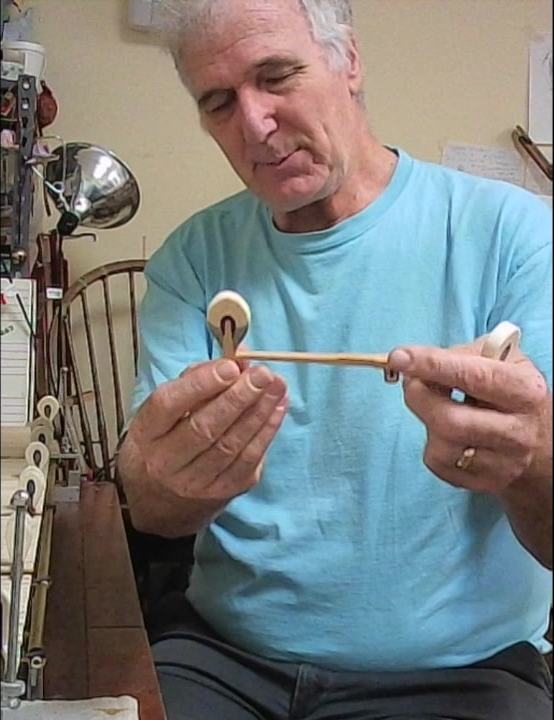 Jeremy Duckles examines a piano hammer while explaining how hammer condition affects the instrument.
